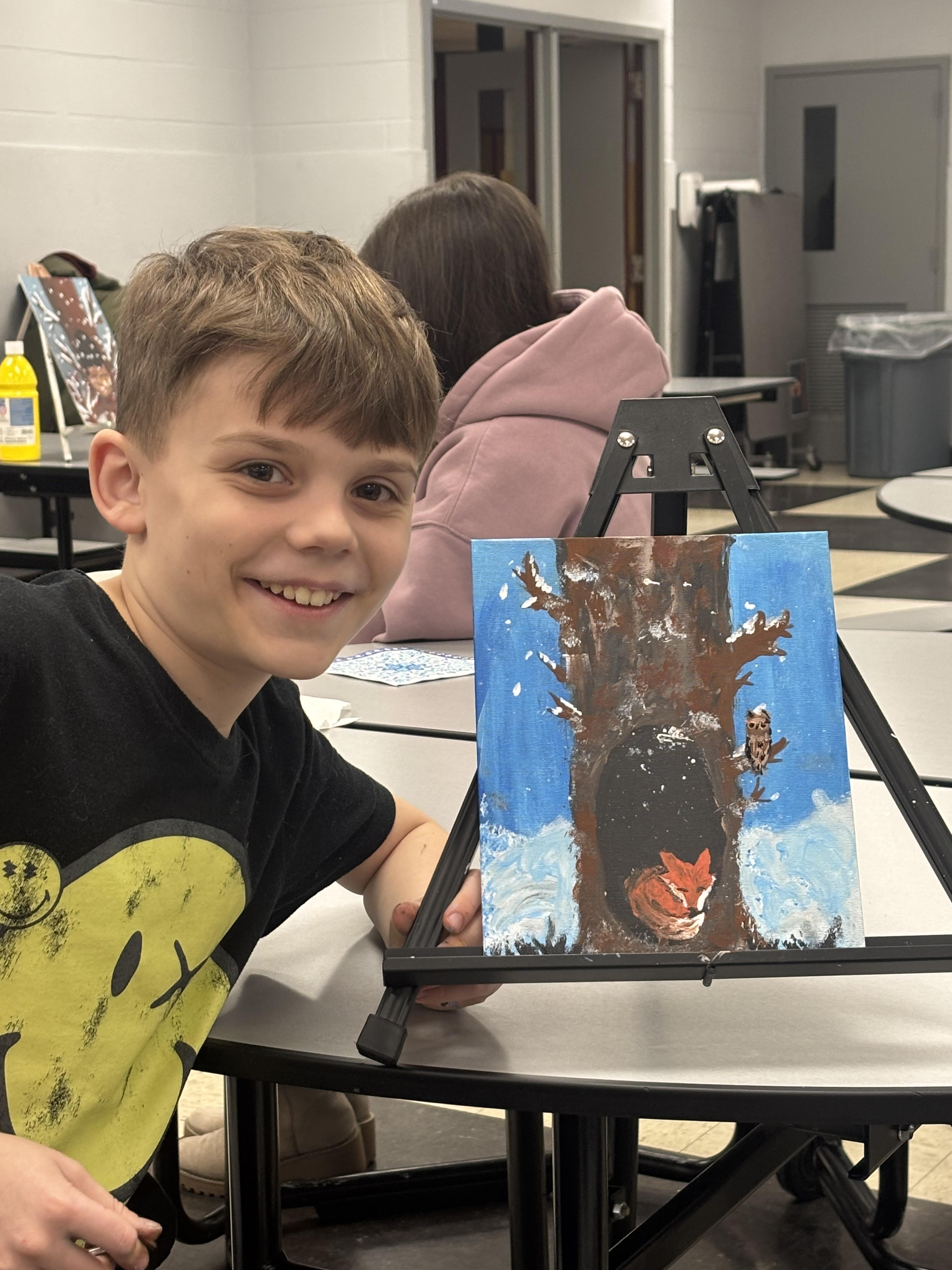 Students shows artwork from Cookies and Canvas night